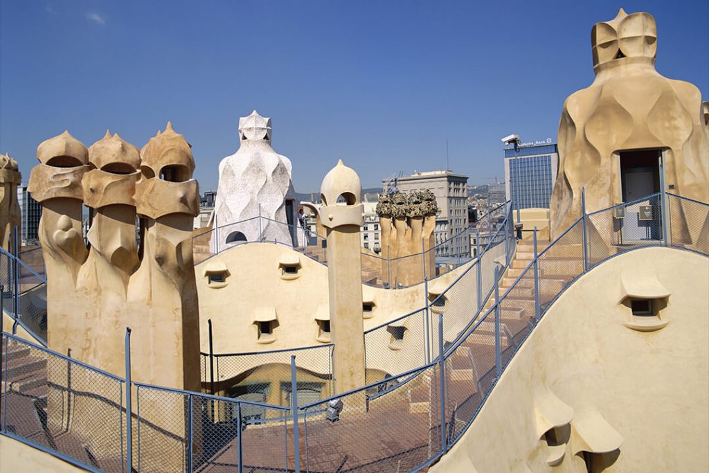 Chimeneas con forma de guerrero en la azotea de La Pedrera con Barcelona al fondo